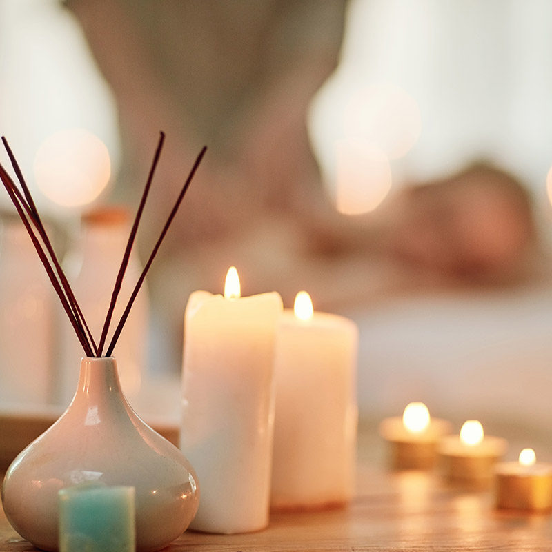 Cropped shot of various pampering essentials in a spa with a young woman in the background